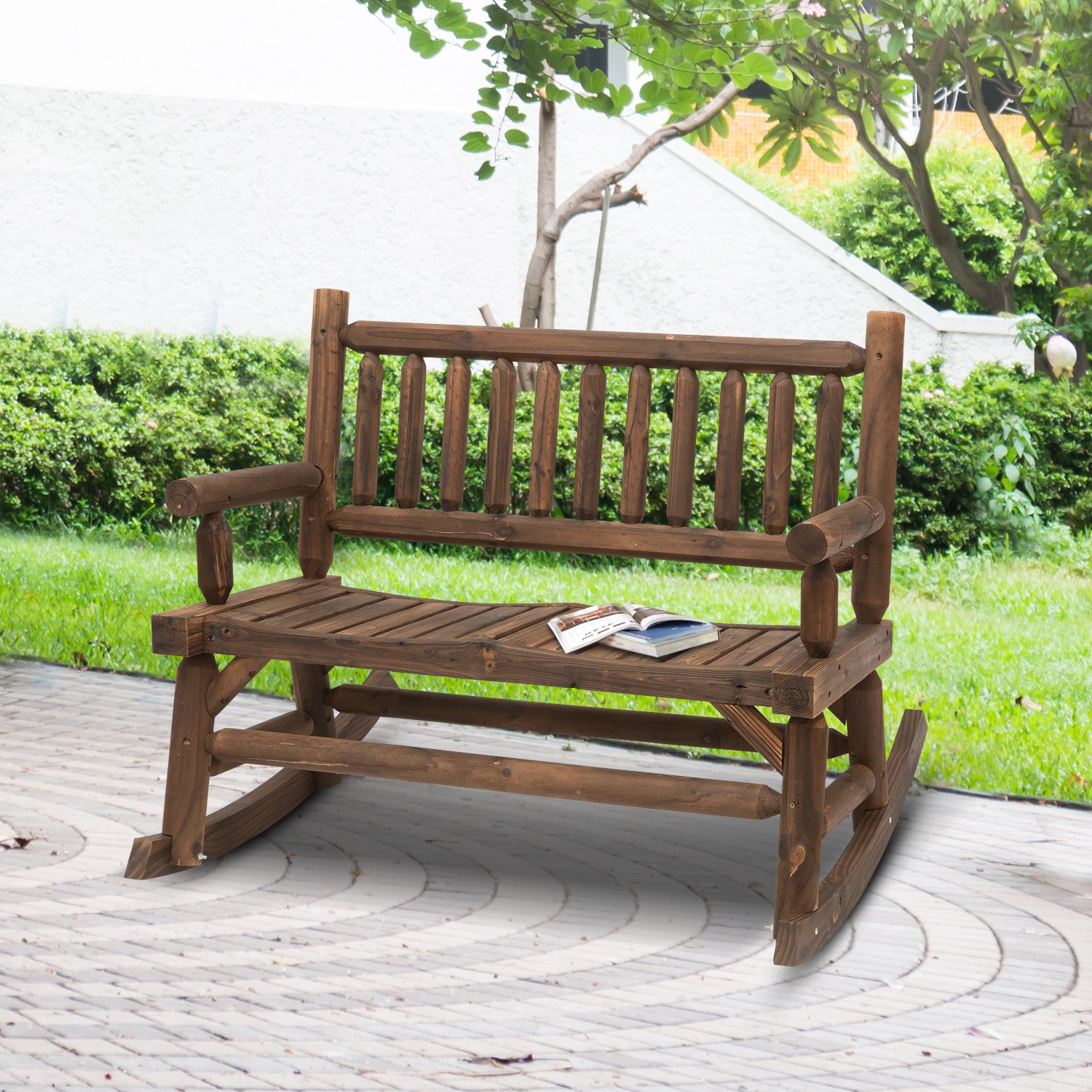 Coocosh Rocking Bench made of durable wood, featuring a rustic brown finish, designed for outdoor relaxation. Dimensions provide ample seating space, set in a serene garden environment.