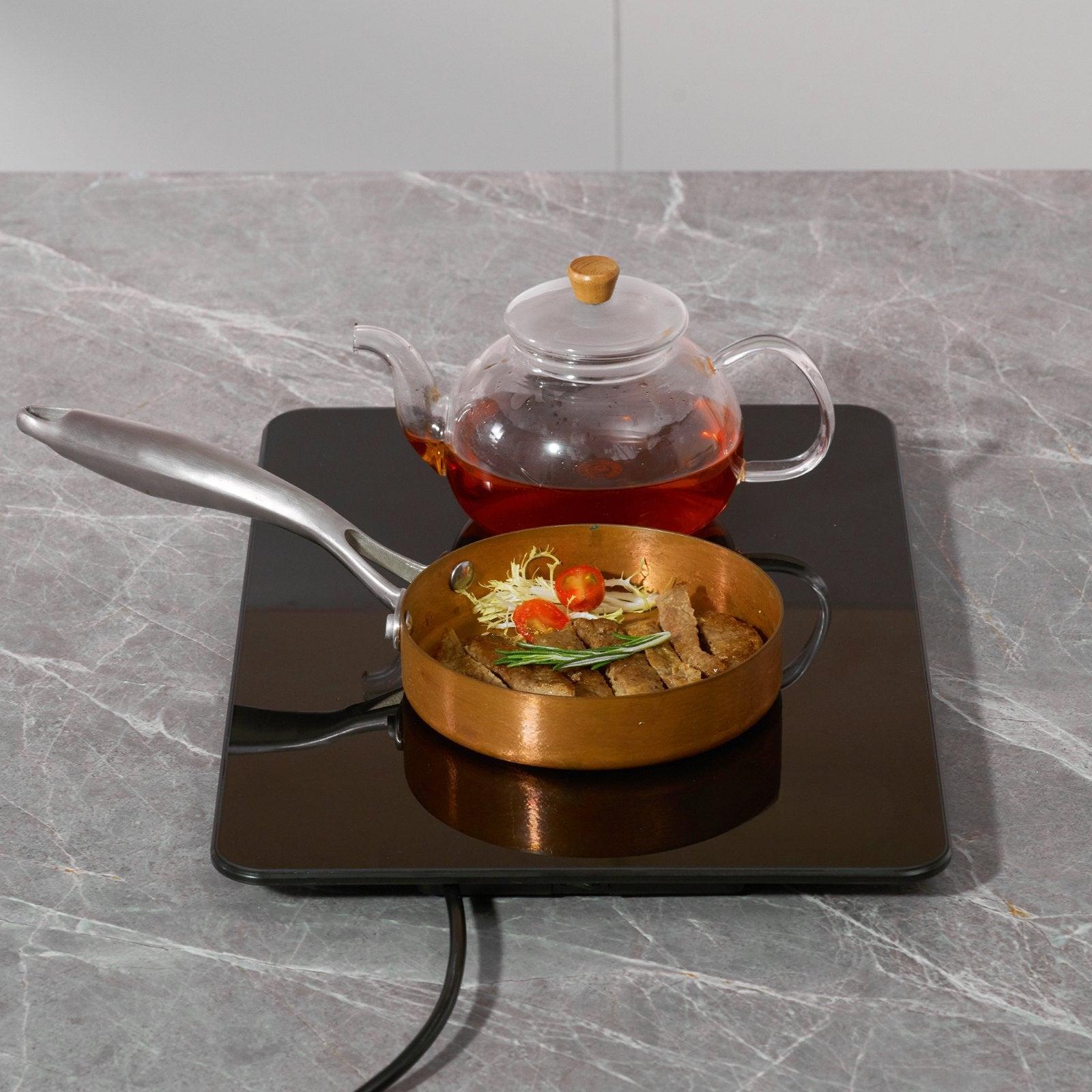Coocosh warming tray made of tempered glass, featuring a sleek black design, ideal for catering and keeping dishes warm at events.
