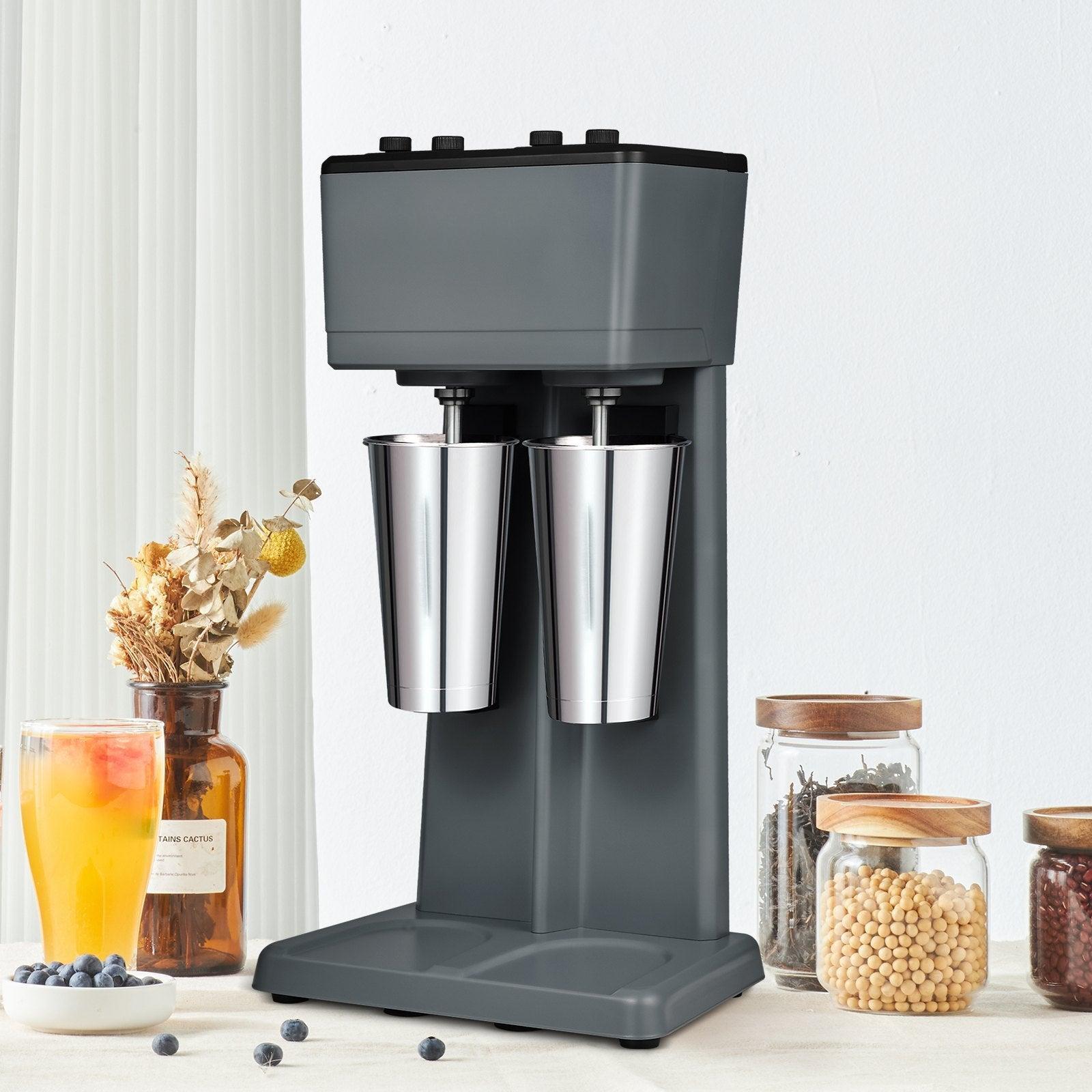 Coocosh Milkshake Maker with Dual Stainless Steel Cups and a sleek grey body, perfect for crafting delicious milkshakes or smoothies. Dimensions fit comfortably on countertops for easy access.