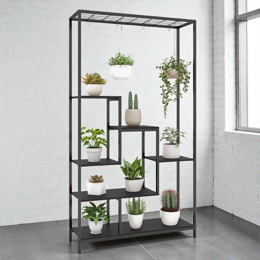 Coocosh black metal plant stand featuring multiple shelves and hanging hooks, showcasing an assortment of potted succulents, cacti, and trailing plants against a white brick wall. This main view highlights the unit's vertical display capability for indoor