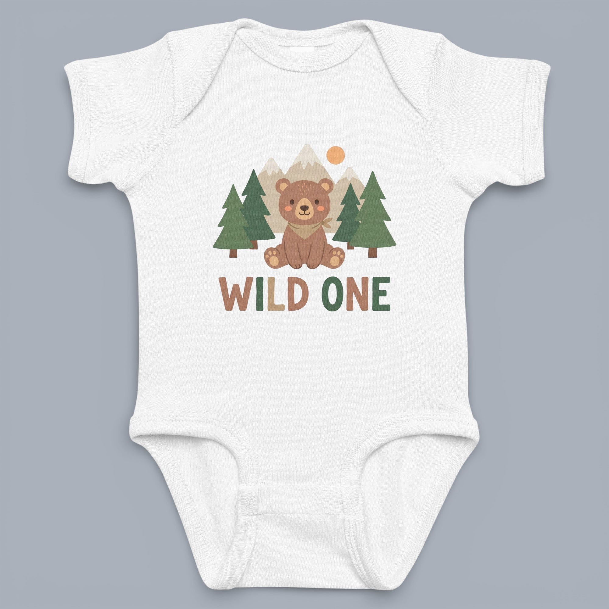 Coocosh Baby Onesie features a 'Wild One' design with a cute bear sitting amongst stylized trees and mountains in neutral tones. The onesie is white and shown laid flat.