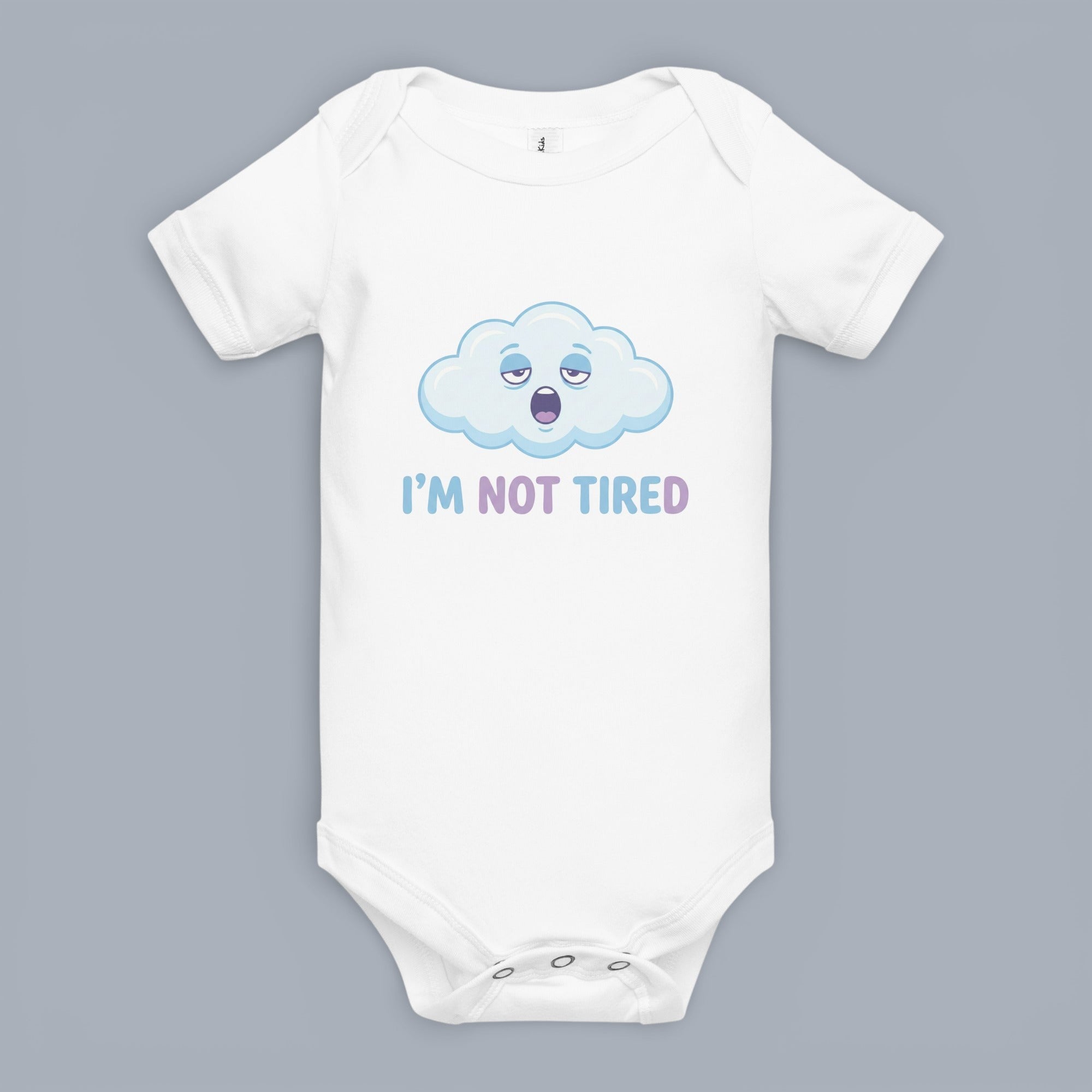 Coocosh baby bodysuit made of soft, breathable cotton featuring a cute, sleepy cloud graphic and the phrase "I'M NOT TIRED" in blue and purple on a grey background. Perfect for babies.