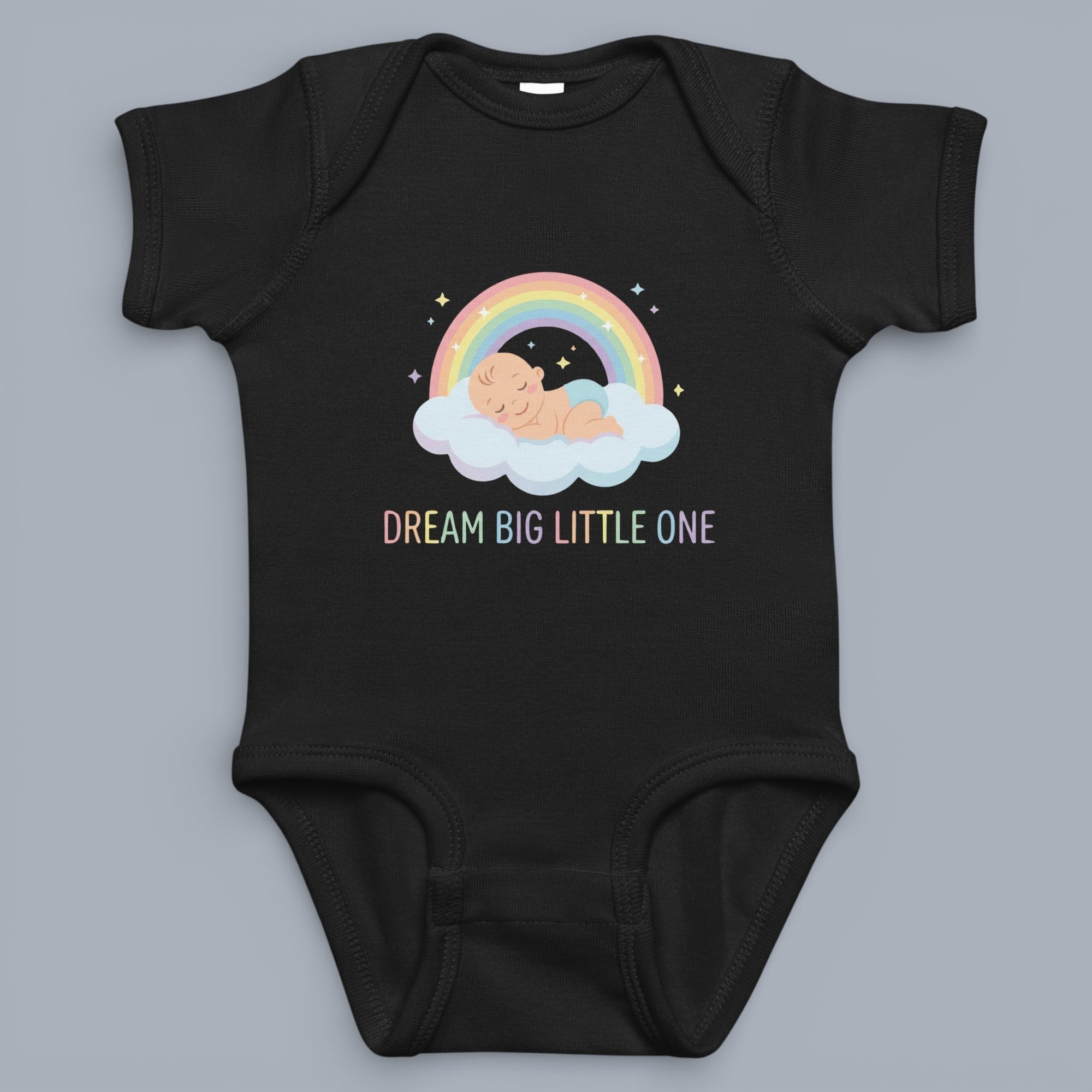 Coocosh baby bodysuit featuring a sleeping baby on a cloud under a rainbow, with pastel colors and the text "Dream Big Little One". Soft, comfortable material in classic black. A heartwarming design for your little dreamer.