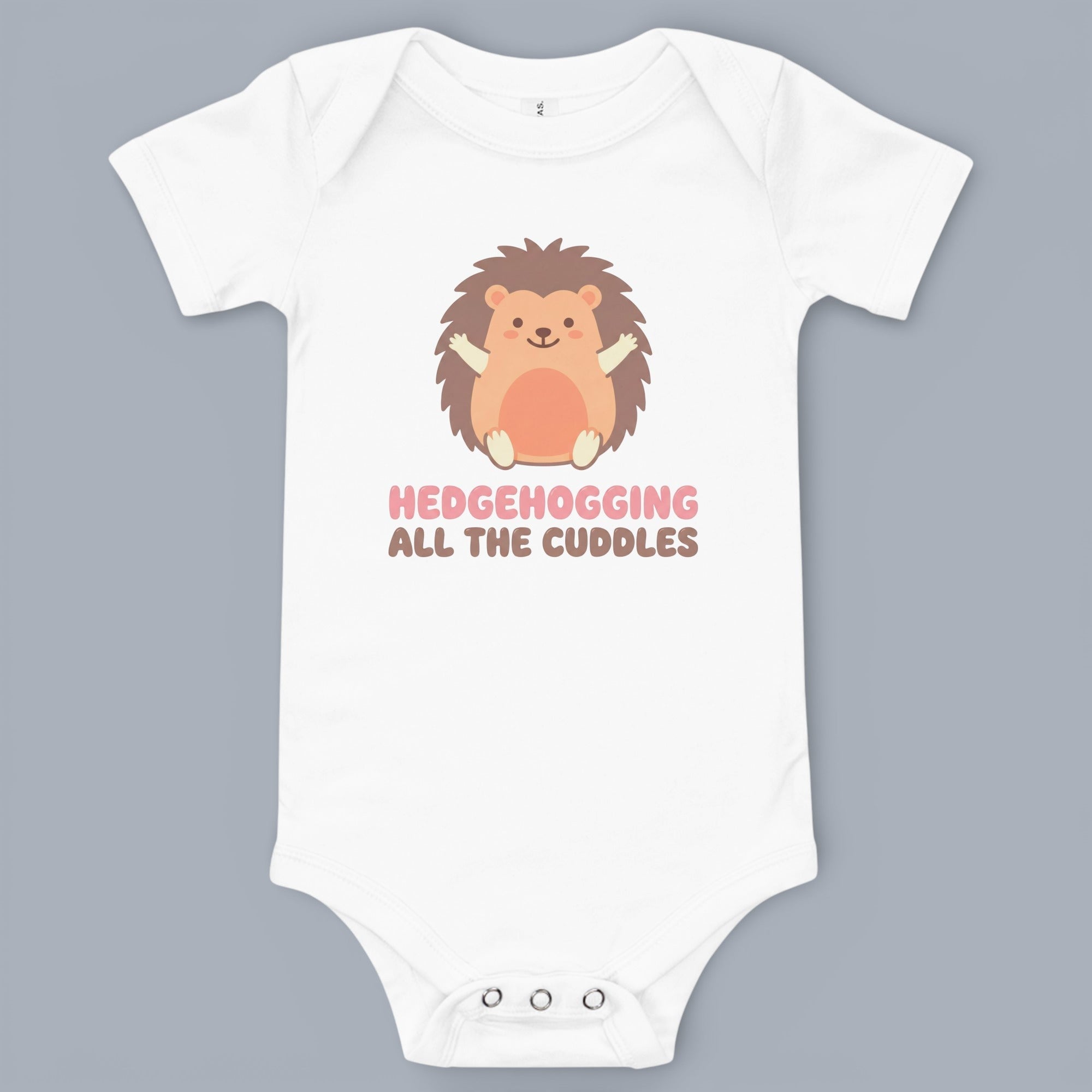 Coocosh Baby Bodysuit featuring a cute cartoon hedgehog design with the phrase "Hedgehogging All the Cuddles" in pink and brown text. Soft, comfortable, and white in color. Front view.