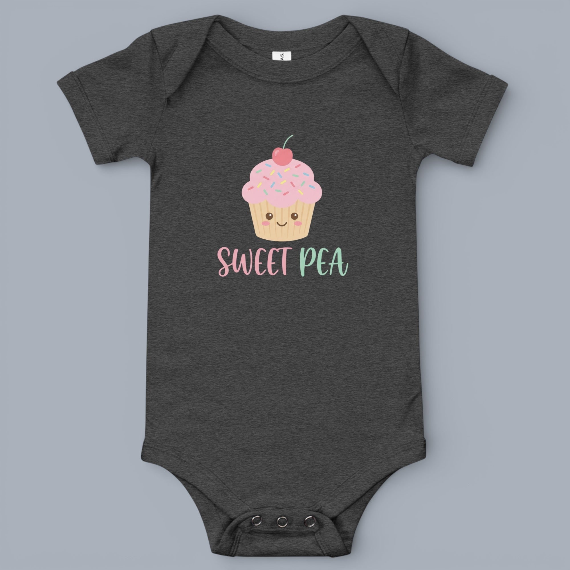 Coocosh baby onesie featuring a cute cupcake graphic with pink frosting and colorful sprinkles, paired with 'Sweet Pea' text in pastel pink and turquoise, a charming and playful design for infants..