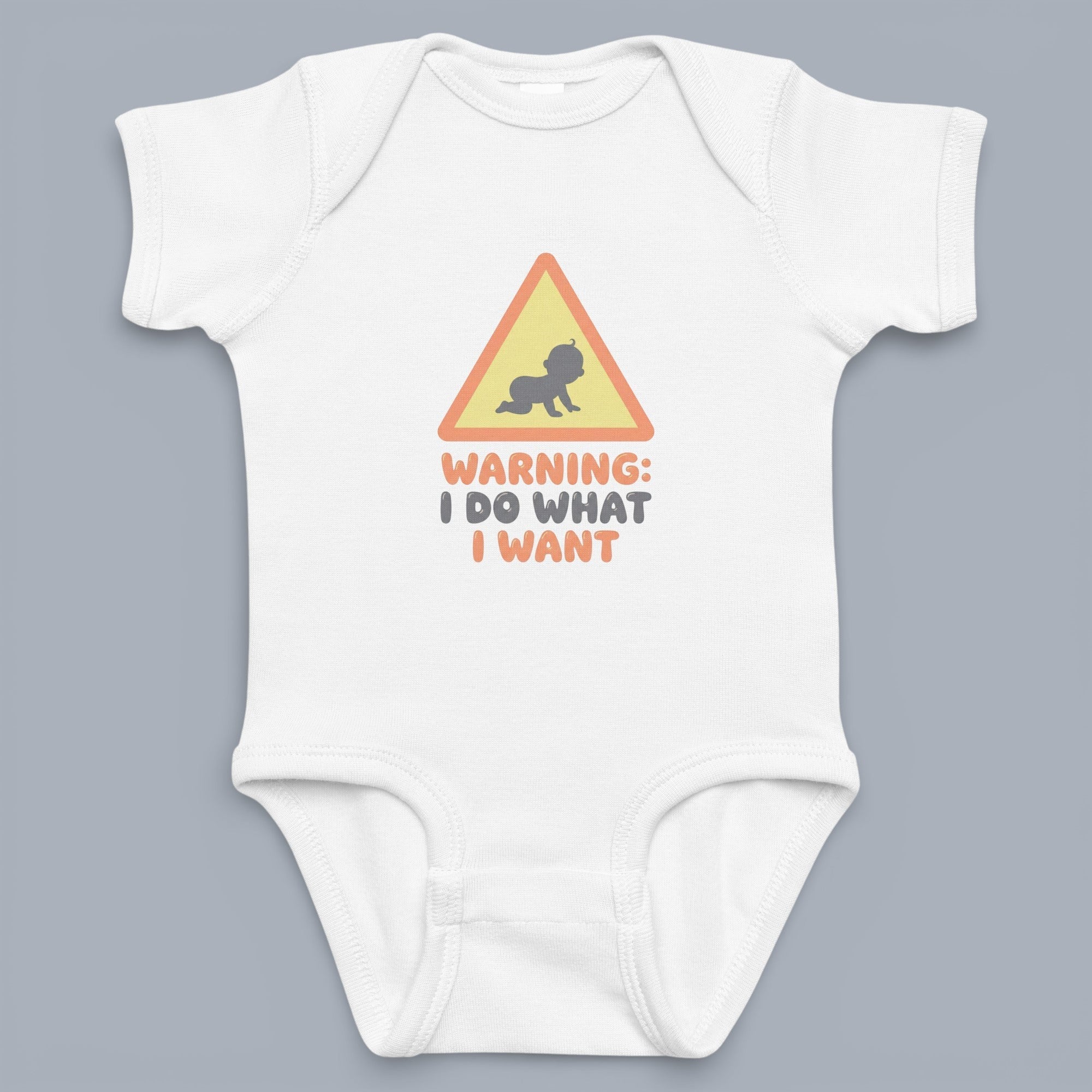 Coocosh baby onesie with a humorous graphic of a baby crawling inside a yellow triangle, overlaid with the text "Warning: I Do What I Want," shown in white on a gray backdrop.
