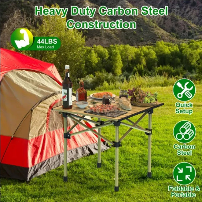 Coocosh Heavy Duty Camping Table with Carbon Steel Construction in a natural setting, featuring a foldable design, capable of holding up to 44 lbs, displayed next to a tent and outdoor cuisine, showcasing its practicality.