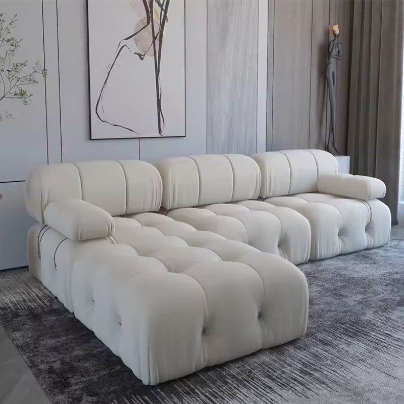 Coocosh Modern Sofa with plush tufted design, featuring soft upholstery in a chic off-white color, ideal for contemporary living spaces. Main view showcasing its spacious L-shape dimensions and ergonomic armrests for comfort.