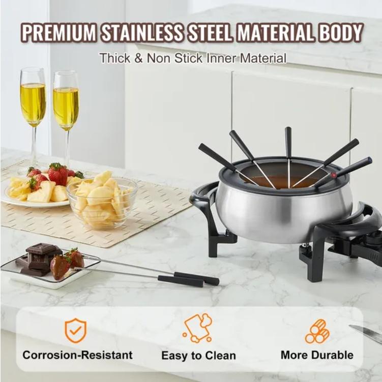 Stainless steel fondue pot with dipping skewers on a marble surface, surrounded by food and drinks.
