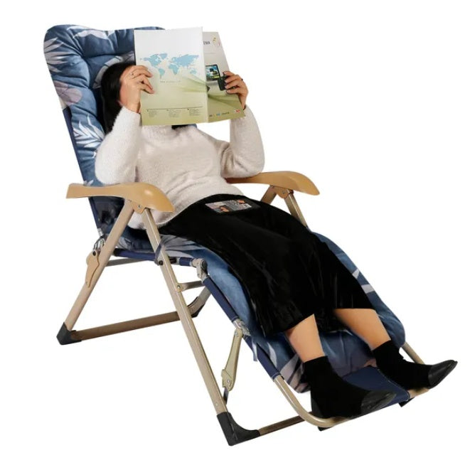 Coocosh Zero Gravity Chair in blue floral print, featuring a reclining design for ultimate relaxation as a person reads a magazine, perfect for outdoor lounging and stress relief.