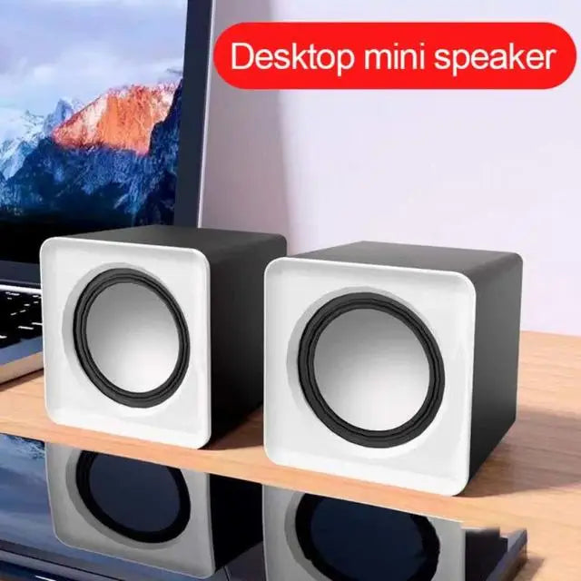 Coocosh compact desktop mini speakers with a sleek black finish and elegant white front grill, designed to elevate your audio experience with high-frequency clarity for immersive gaming and music playback, while seamlessly fitting into any workspace.