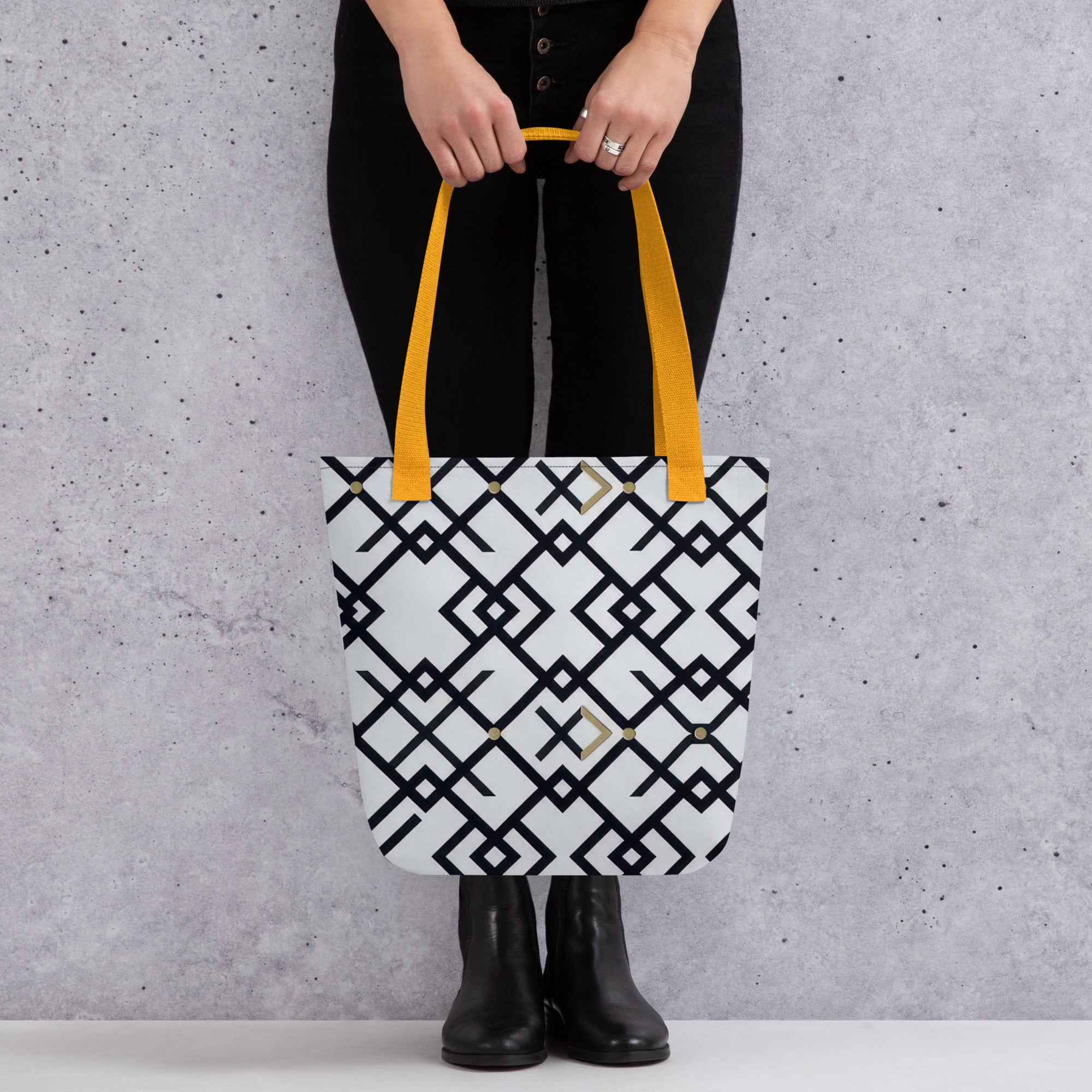 Coocosh Midnight Meridian tote bag, showcasing an eye-catching geometric black and white pattern. Features durable 100% polyester and vibrant yellow handles, perfect for stylish storage on-the-go, elevating everyday outings with contemporary flair.