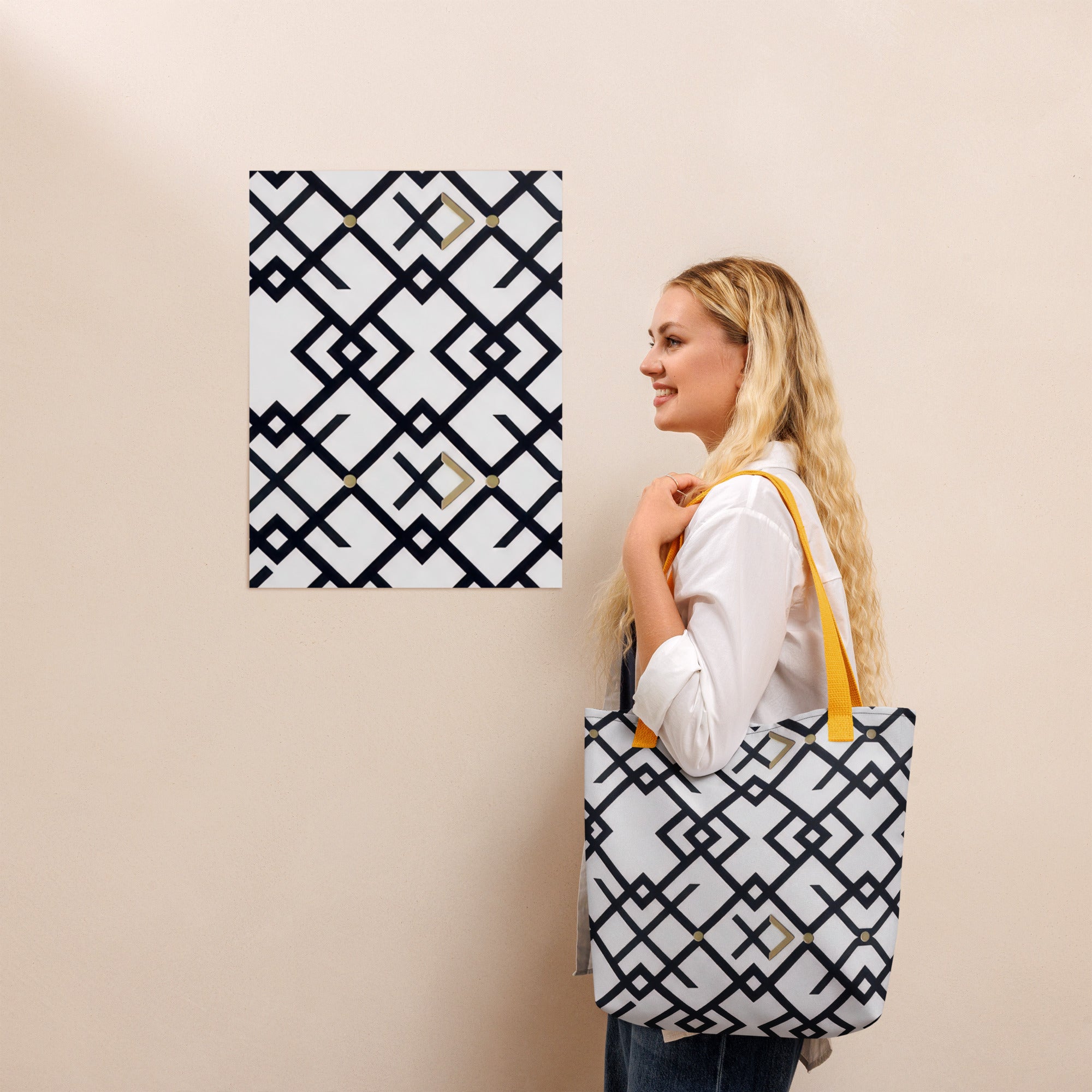 Coocosh Midnight Meridian tote bag, featuring a striking geometric black and white pattern that aligns with the wall’s design, exudes modern elegance. Crafted from durable 100% polyester with cotton handles, this spacious and weather-resistant accessory elevates any ensemble.