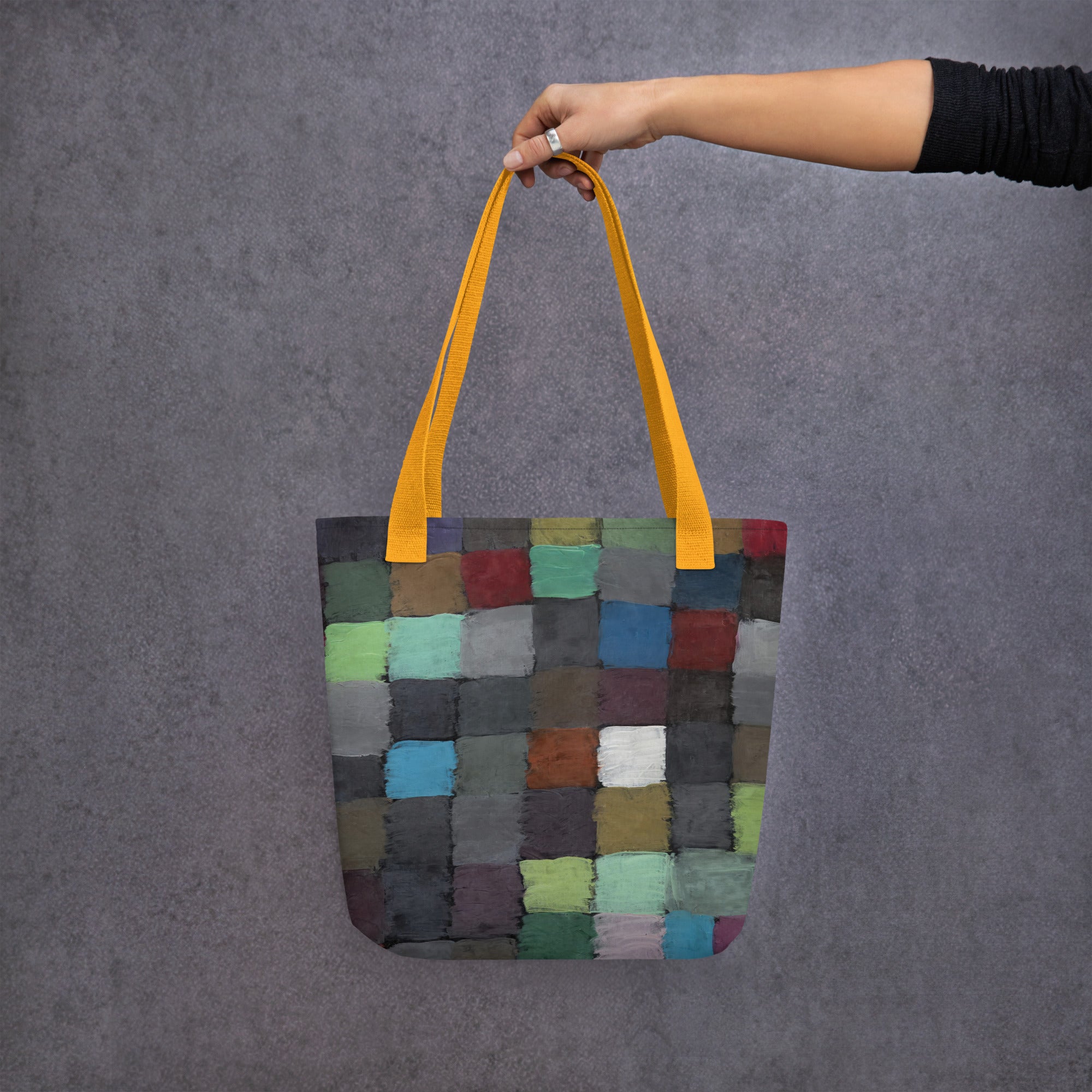 Coocosh vibrant patchwork tote bag, featuring an array of colorful squares and sturdy yellow straps, perfect for both errands and beach days, combining functional design with a lightweight, durable polyester construction for effortless style and versatility.