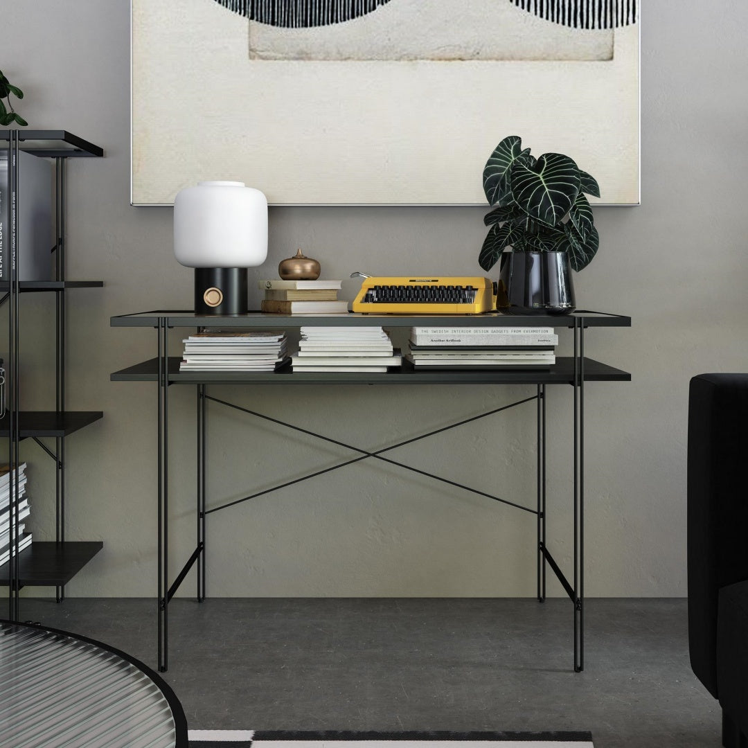 Coocosh Modern Console Table in Black Metal with a compact design and a striking X-frame base, perfectly styled with a lamp, vintage typewriter, plant, and books in a chic home office setup. This lifestyle shot highlights the table's functionality and aes