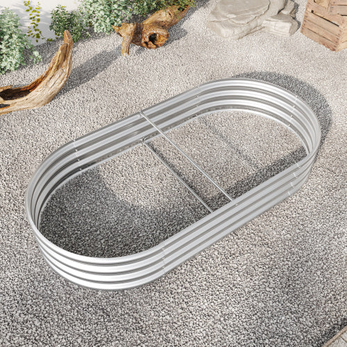 Coocosh oval raised garden bed, made of corrugated galvanized steel, in a silver finish, offering ample space for your plants, shown from a top-down perspective on a gravel base with decorative driftwood and foliage for context.